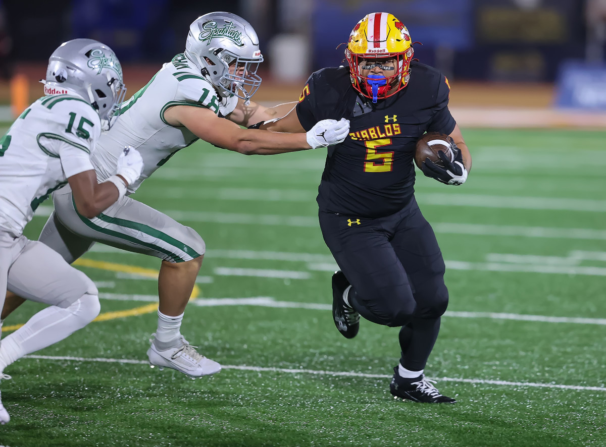Mission Viejo's Hinesward Lilomaiava is grabbed by De La Salle's Drew Cunningham. 